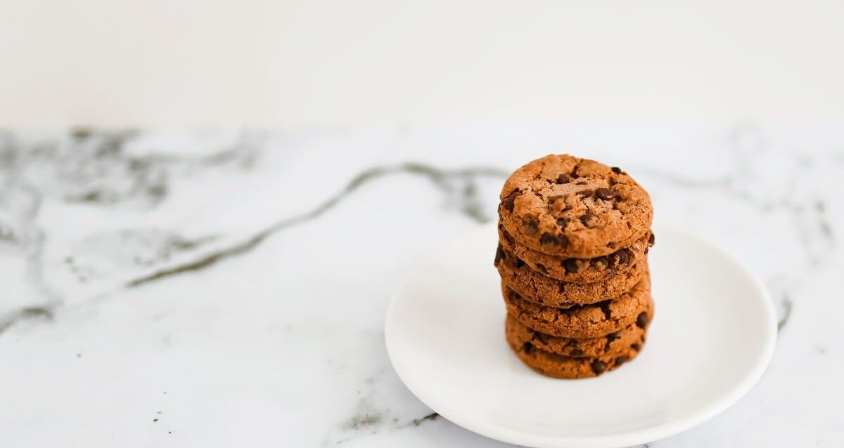 baked-cookies-stack-white-plate-marble-backdrop-e1715758513481