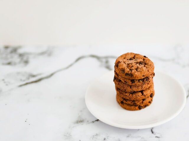 baked-cookies-stack-white-plate-marble-backdrop-e1715758513481